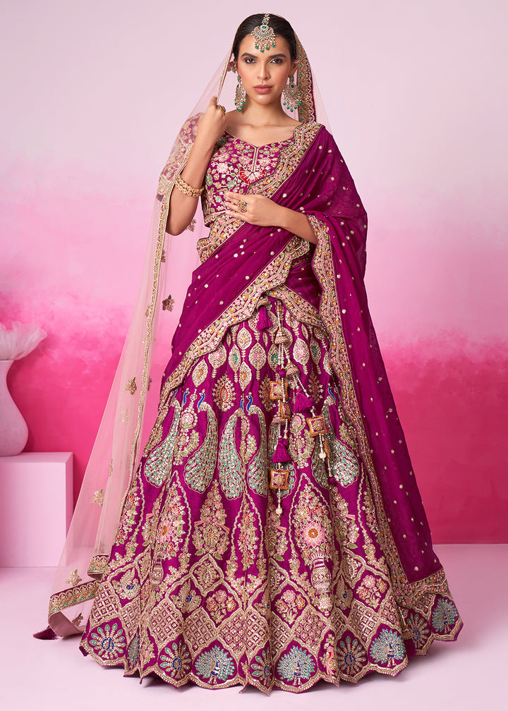A woman wearing a traditional magenta purple silk lehenga choli with embroidery work and a net dupatta.