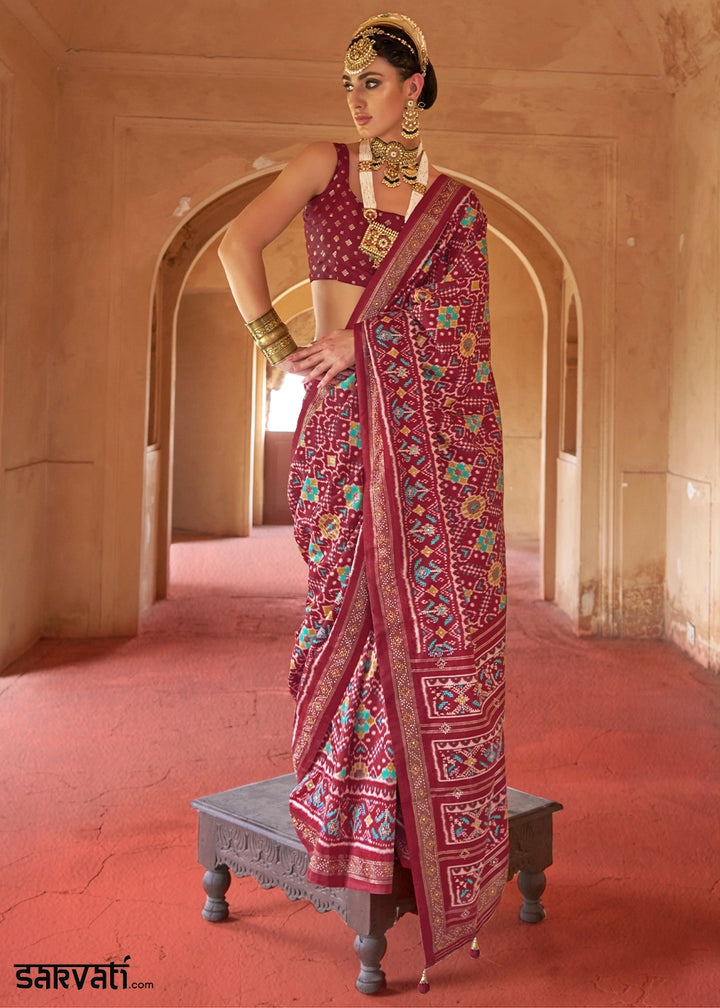 Woman in a traditional saree standing in an architectural setting